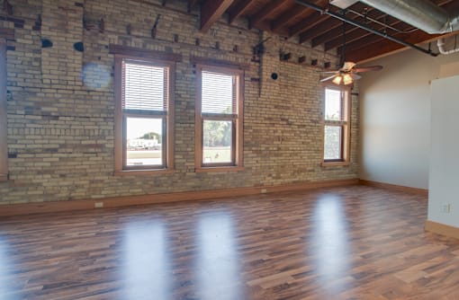 A room with wooden floors and a brick wall,Kassenborg Apartments, Moorhead,