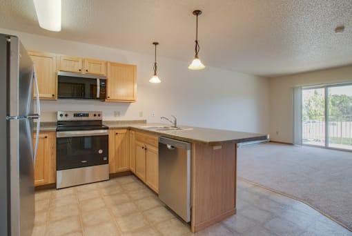 A kitchen with wooden cabinets and stainless steel appliances, Kassenborg Apartments, Moorhead, MN