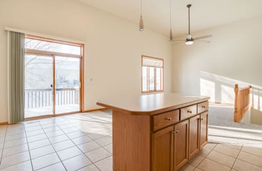 A kitchen with a wooden counter and tile floor.