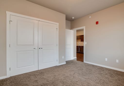 A room with white doors and a carpeted floor.