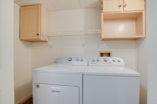 A small laundry room with a washer and dryer. at Eighth Street Manor Apartments, Fargo, North Dakota