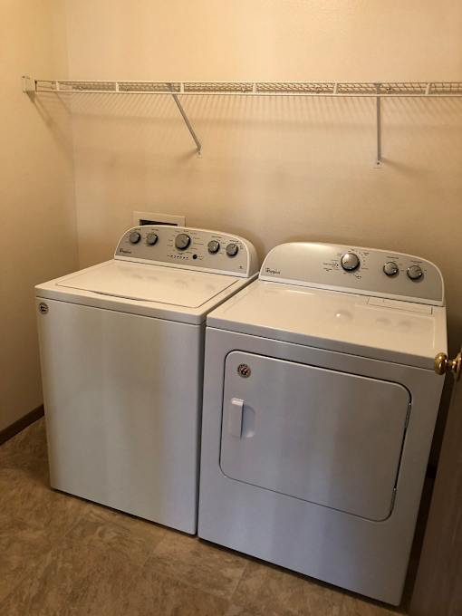 Two front loading washing machines in a laundry room.