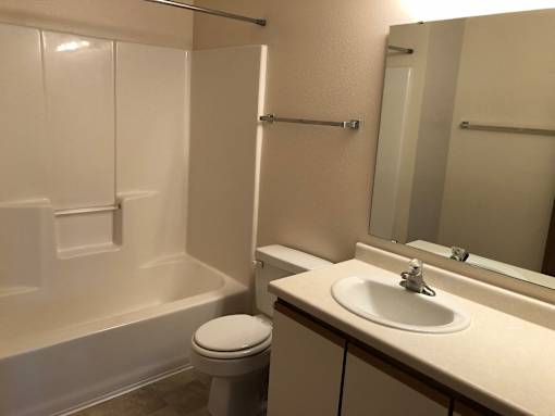 A white toilet sits next to a white sink in a small bathroom.