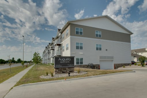 a large apartment complex with a sign in front of it at Augusta Apartments, Fargo, 58104