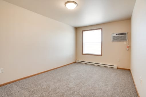 the living room of an empty house with a window at Augusta Apartments, Fargo, 58104
