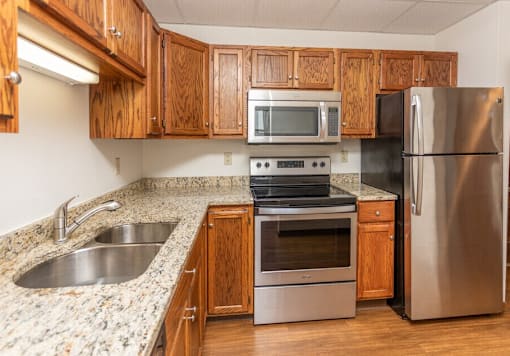 A kitchen with a stove, oven, sink, and refrigerator at Block 6 Apartments, North Dakota, 58103