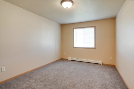 an empty living room with a window and carpet at Waterstone Apartments, Minnesota, 56560