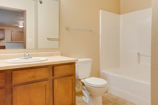 a bathroom with a toilet and a sink and a shower at Waterstone Apartments, Moorhead