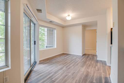 A room with a sliding glass door and a wooden floor.
