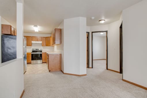 A kitchen area with a refrigerator, oven, and cabinets.