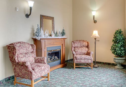 Two chairs and a fireplace in a room at Savanna Apartments, Minnesota