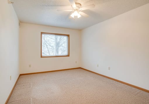 A room with a carpeted floor and a ceiling fan at Savanna Apartments, Minnesota, 56303