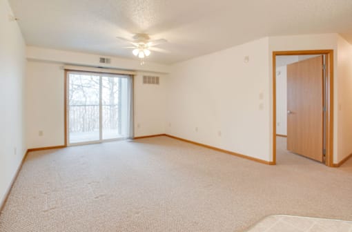 A room with a carpeted floor and a ceiling fan at Savanna Apartments, St Cloud, MN, 56303