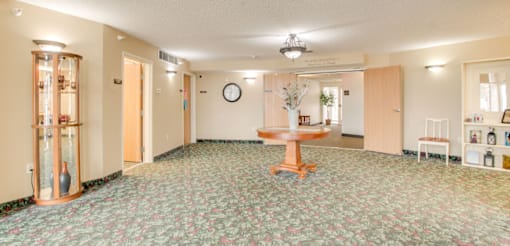 A room with a round mirror on the wall and a table in the middle at Savanna  Apartments, St Cloud, MN