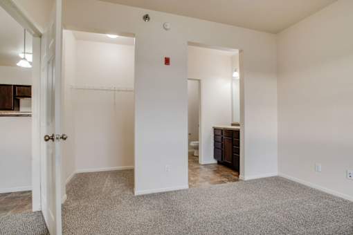 A room with a carpeted floor and a white door.
