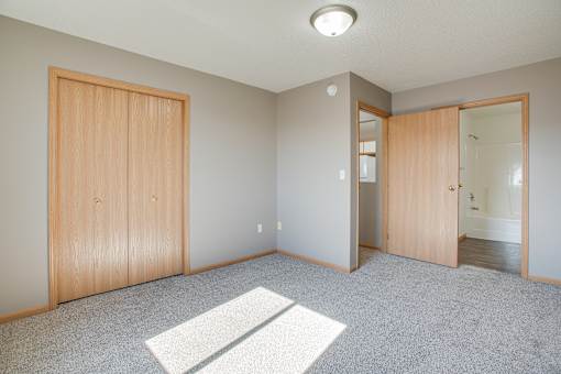 A room with a carpet and a door.