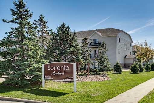A sign for Sorrento Apartments stands in front of a building.