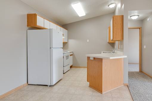A kitchen with a white refrigerator, a white oven, and a white dishwasher.