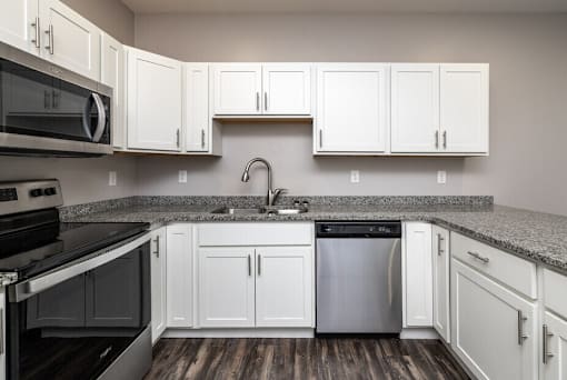 A kitchen with white cabinets and a black stove top oven.