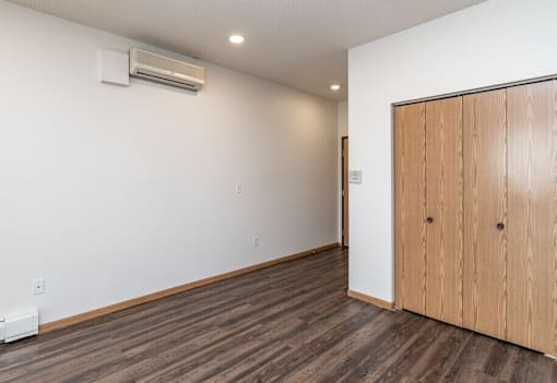 A room with a wooden floor and a wooden door.