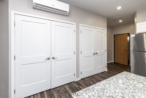 A kitchen with white cabinets and a stainless steel refrigerator.