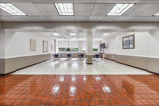a large community room with a table and chairs in the middle of it