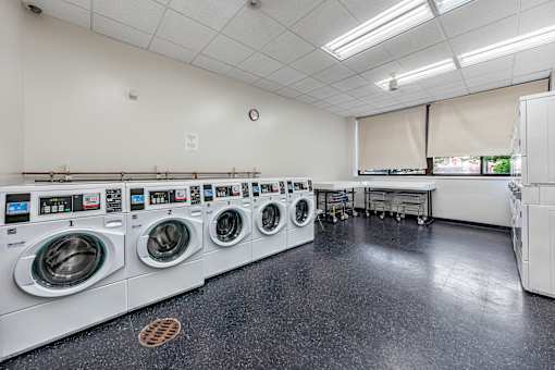 a spacious laundry room with washers and dryers and a row of washing machines  at 500 Manila apartments in Jersey City