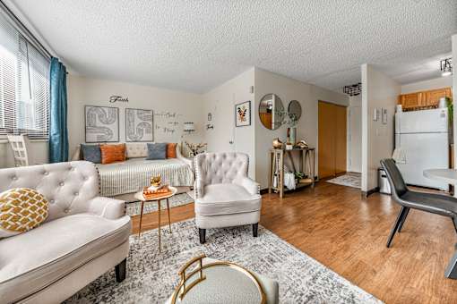 Apartment living room with a couch and chairs and a kitchen with a refrigerator in Jersey City