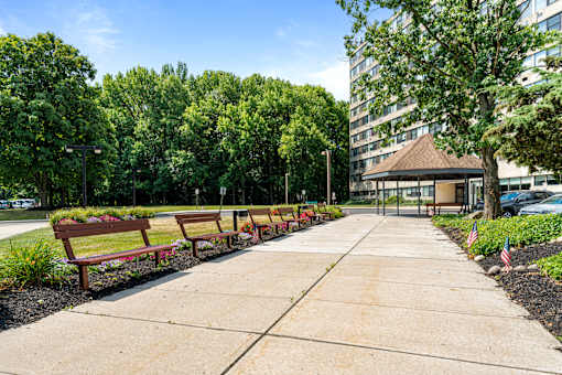 a row of benches on a sidewalk in front of a building