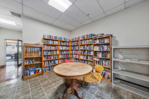 a library with a table and chairs and shelves of books