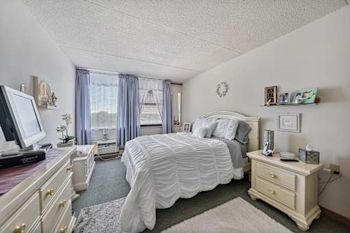 a bedroom with a bed and a dresser and a tv