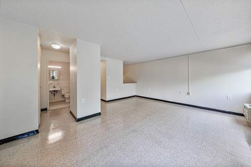 the living room and dining room of an empty apartment with white walls and tile floors