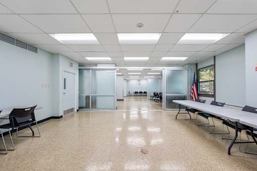 a large room with tables and chairs and a flag