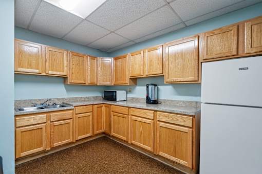 A kitchen with wooden cabinets and a white refrigerator.
