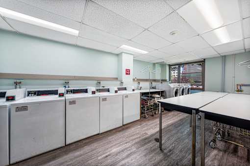 a classroom with a row of washing machines and a table