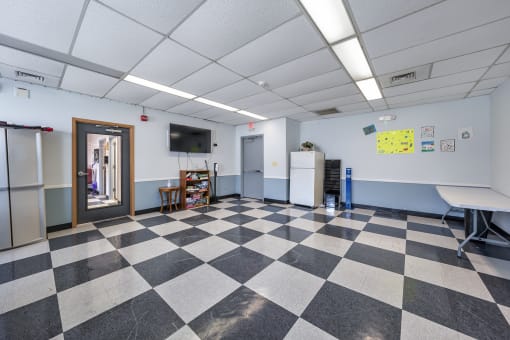 a room with a checkered floor and a door to a classroom