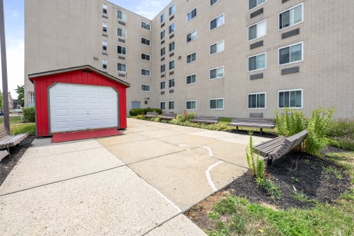 an apartment building with a red shed and a white garage door