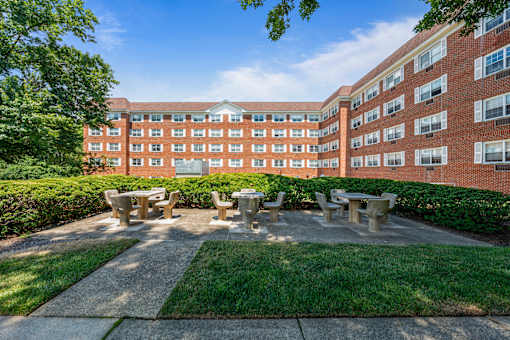 a picnic area with benches in front of a brick building