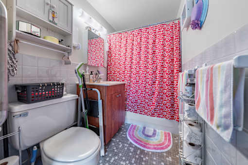 a small bathroom with a red and white shower curtain