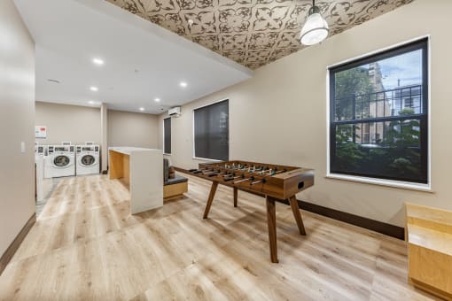 a game room with a foosball table and a large window
