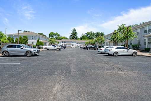 a parking lot with cars in front of apartment buildings