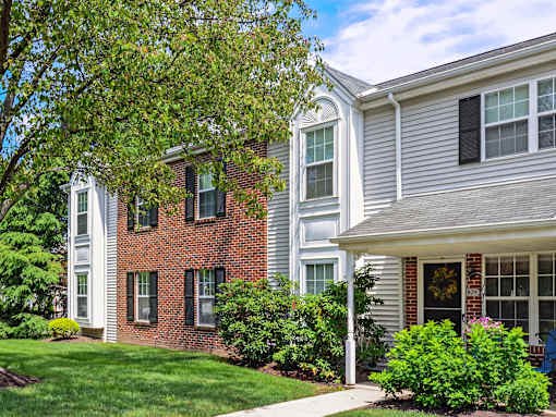 Beautiful exterior of Westridge gardens with green grass, tall trees, and bushes