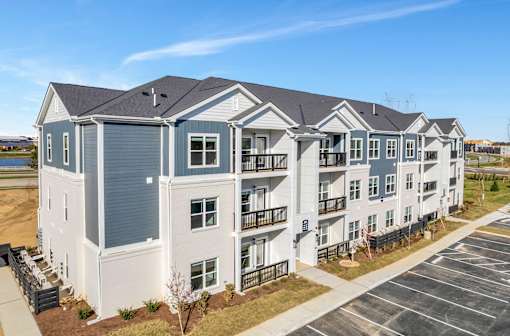 an image of an apartment building with a parking lot