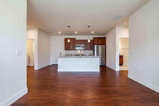A kitchen with a white island and wooden floors.