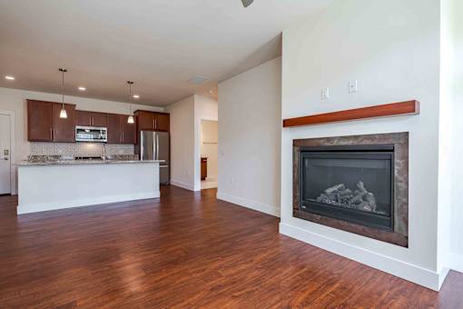 A modern kitchen with a wood floor and a fireplace.