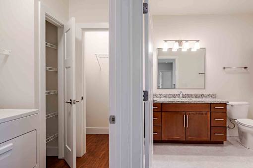 A bathroom with a white toilet, a sink, and a mirror.