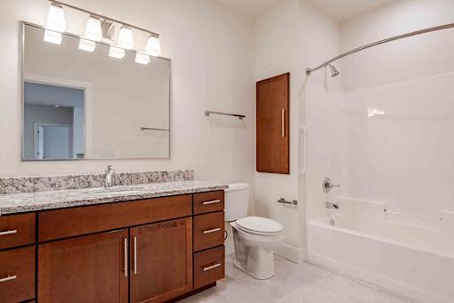A bathroom with a white tub, sink, and toilet.