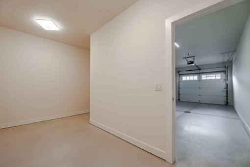 A white room with a doorway leading to another room.
