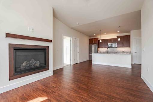 A large open living room with a fireplace and wooden floors.