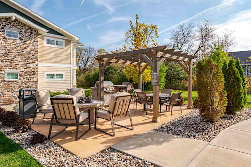 A patio with a table and chairs under a pergola.